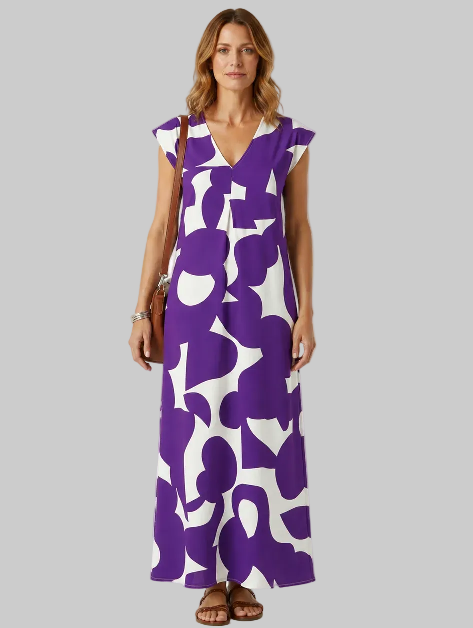 Woman wearing a purple and white patterned dress on a light gray background