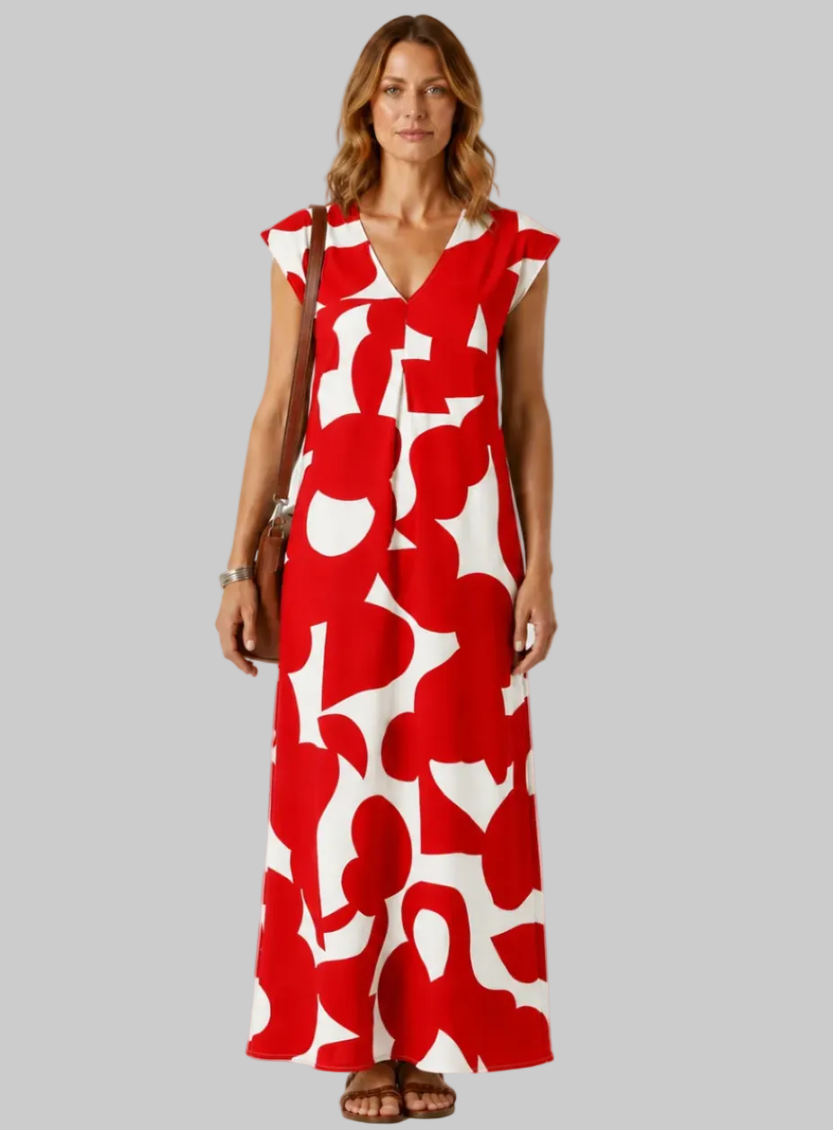 Woman wearing a red and white patterned dress on a plain background